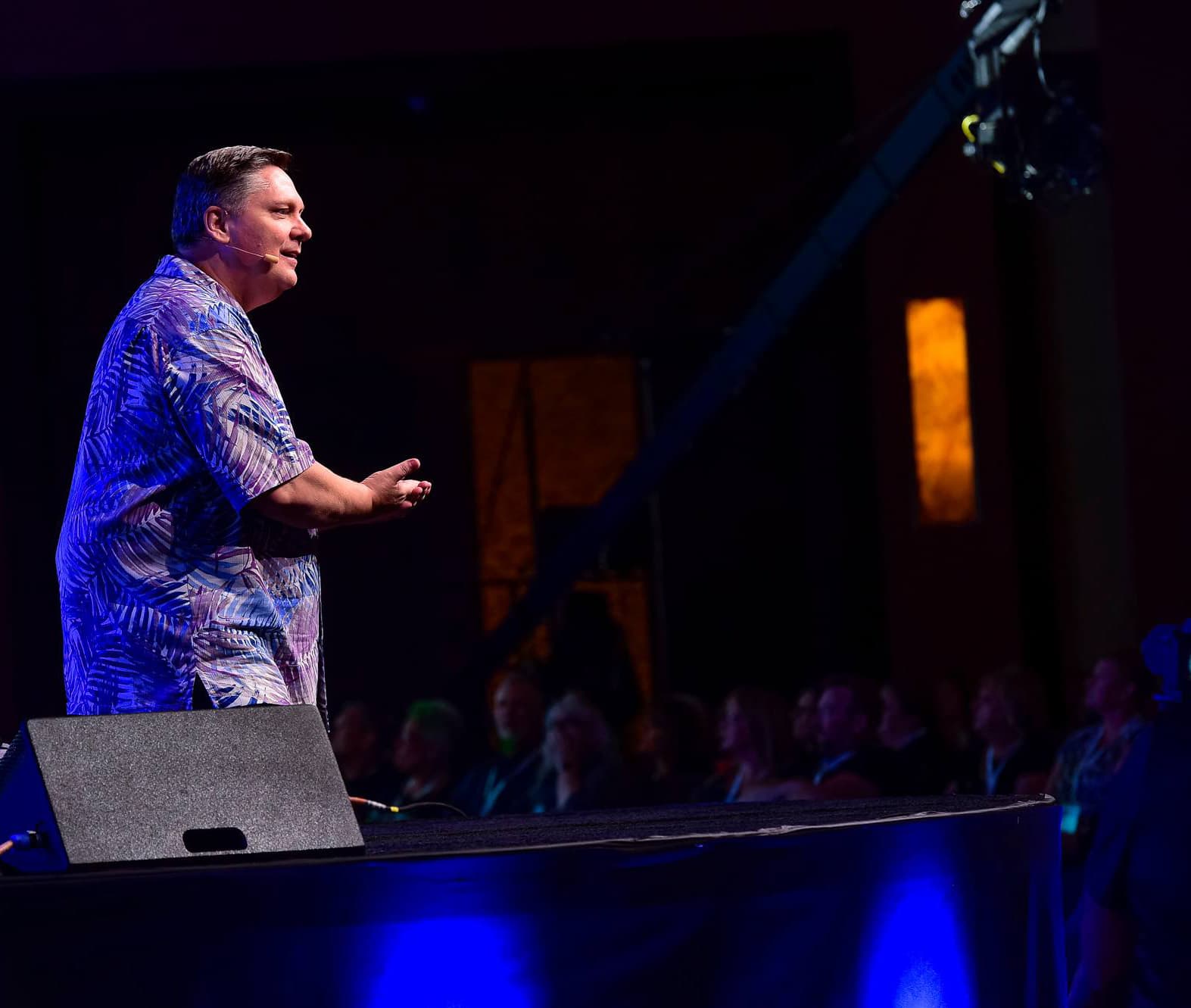Robert Hollis speaking on stage to an audience